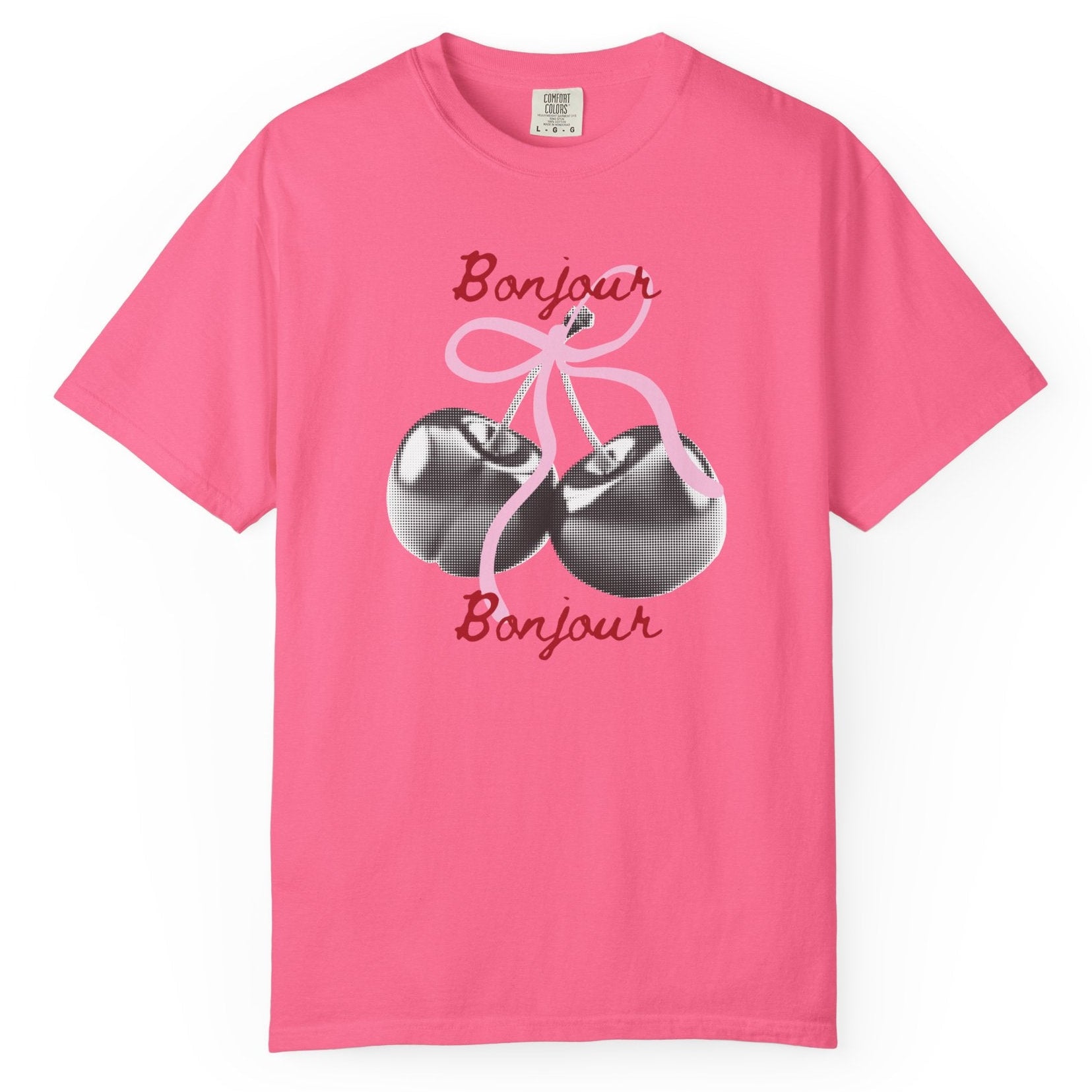 Pink t-shirt with cherry design and 'Bonjour' text on a white background