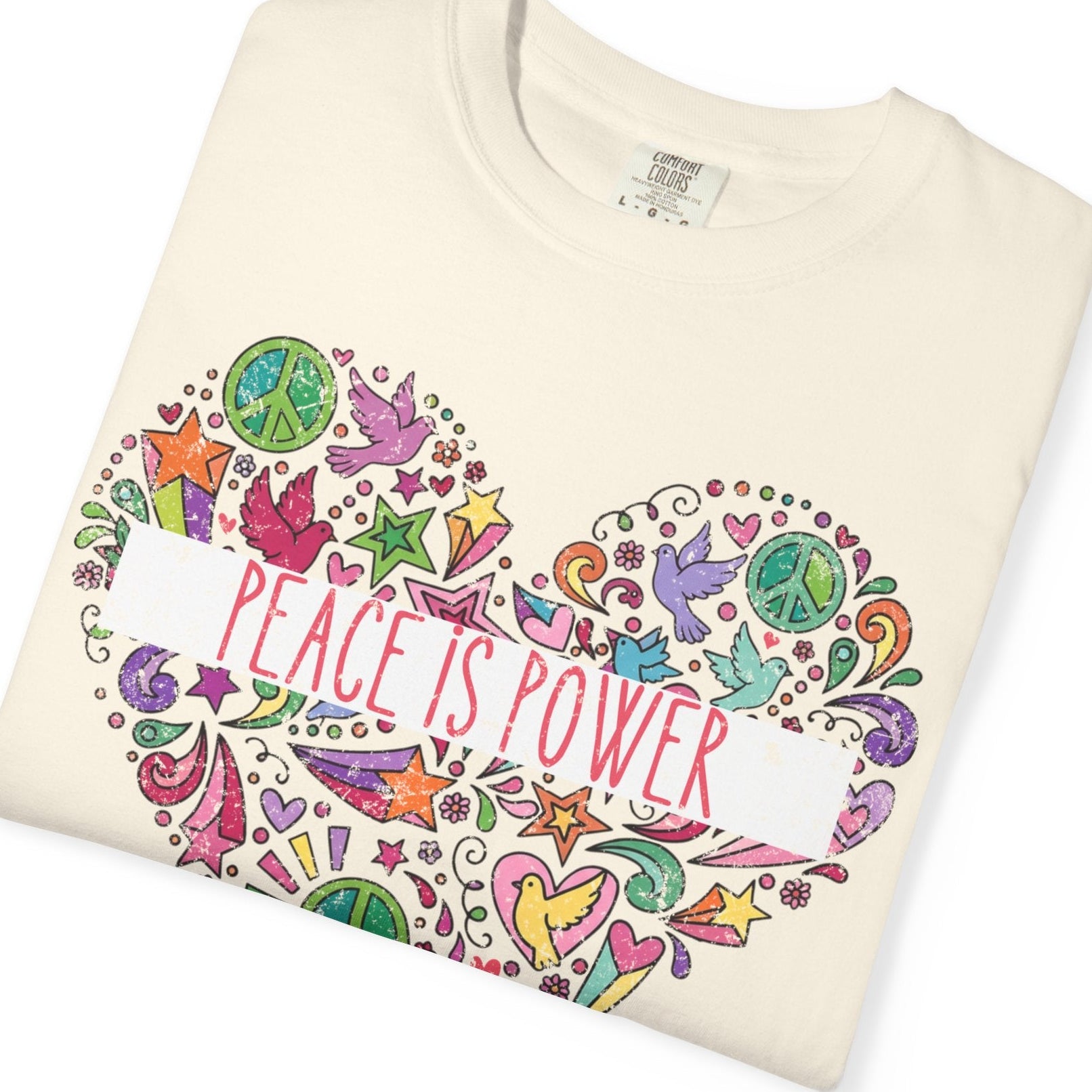 Folded t-shirt with colorful design and 'Peace is Power' text with doodles enclosed in a heart